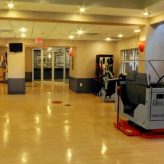 An empty gym with exercise equipment and a well-lit interior.
