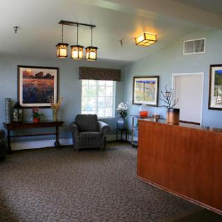 A cozy and welcoming lobby space featuring comfortable furniture, decorative artwork, and warm lighting.