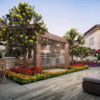 A beautifully landscaped outdoor garden area with lush greenery and vibrant flowers surrounding a modern pergola.