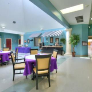 A bright and colorful dining area featuring blue walls, purple tablecloths, and comfortable seating.