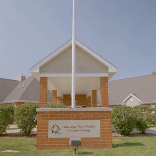 Front view of a school building with a prominent flagpole and brick entrance.