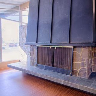 A modern stone fireplace enhances the warm ambiance of a spacious living room.