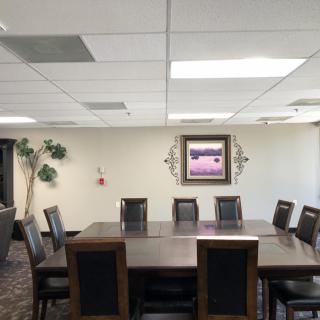 A well-lit conference room with a large meeting table, chairs, and decorative elements on the walls.