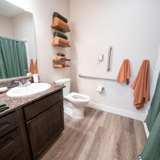 A modern bathroom featuring sleek storage solutions and a warm color palette.