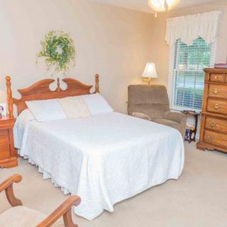 A cozy bedroom with a double bed, wooden furniture, and warm lighting.