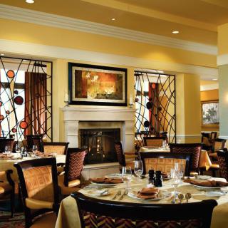 An elegant restaurant interior with a warm, inviting atmosphere and a central fireplace.
