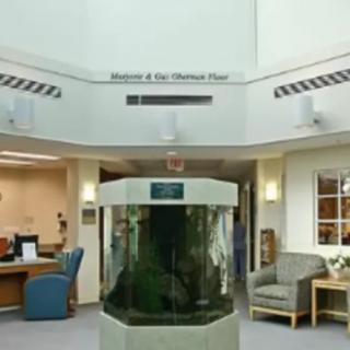 A lobby featuring a central aquarium with seating and a reception desk.