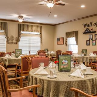 A well-arranged dining room with elegantly set tables and warm decor.