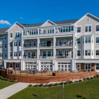 A modern residential apartment building with multiple balconies on a sunny day.