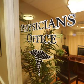 Entrance to a physician's office featuring glass doors with medical emblem.