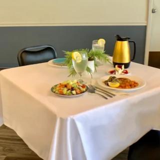 A neatly set dining table with plates of food and drinks in a restaurant setting.