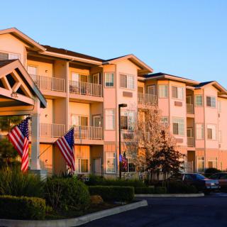 A residential apartment building adorned with flags during sunset.