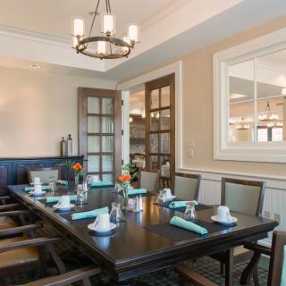 A beautifully decorated dining room with an elegant table setup and chandelier lighting.