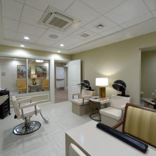 A modern salon interior with hairdressing stations and a comfortable waiting area.
