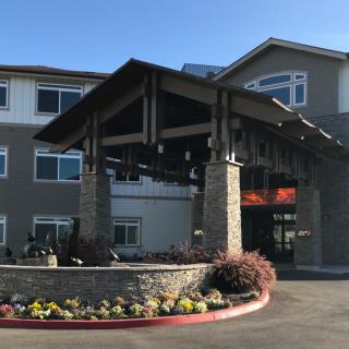 A modern building entrance with stone accents and landscaped surroundings.