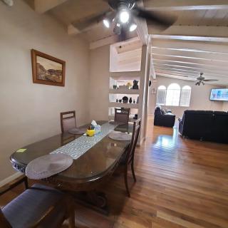 An open dining and living area with wood flooring and a ceiling fan.