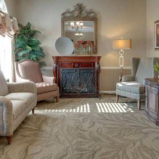 A cozy living room with armchairs, a fireplace, and decorative elements.