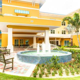 A colorful building featuring a central fountain surrounded by landscaped gardens.