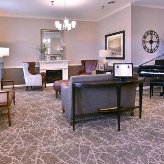 A beautifully designed living room featuring a piano, fireplace, and stylish furniture.