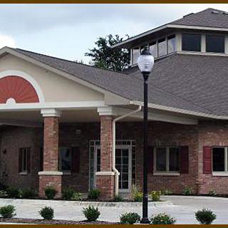 A modern brick building with a gabled roof and a nearby lamp post.