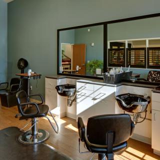 A modern hair salon interior with styling chairs and mirrors.