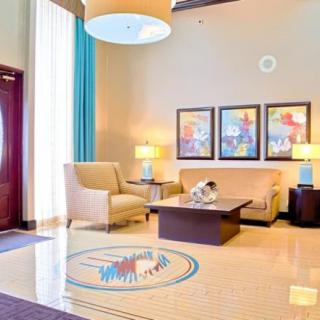 A modern lobby featuring comfortable seating, stylish lamps, and colorful artwork.