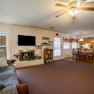 A spacious living room with a fireplace, television, and adjacent dining area.