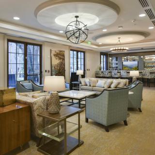 A spacious and elegantly designed living room with comfortable seating and a modern chandelier.