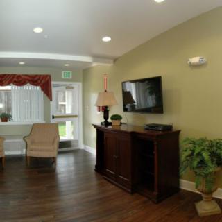 A cozy living room with a TV, armchair, and decorative elements.