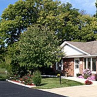 A suburban house surrounded by trees and well-maintained landscaping.