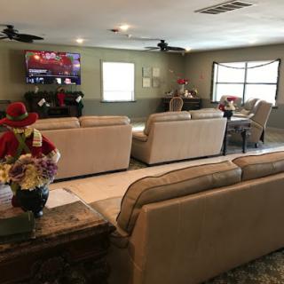 A spacious and inviting living room with comfortable sofas, a television, and natural light coming through the windows.