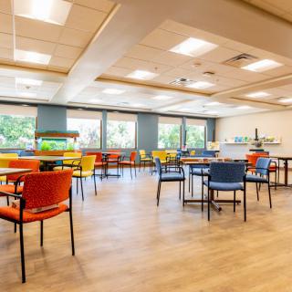 An empty cafeteria with colorful chairs and tables.