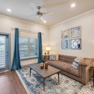A cozy living room with a brown sofa, stylish coffee table, and blue curtains.