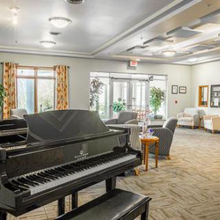 A modern and comfortable living room featuring a grand piano and stylish furnishings.