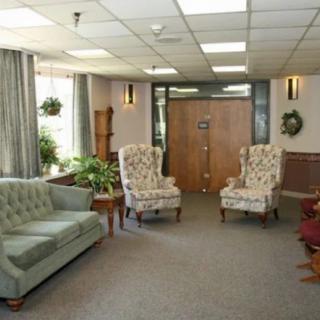 A cozy waiting room with comfortable seating and plants.