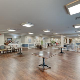 A spacious dining area with wooden floors and ample seating.