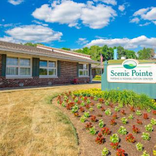 The Scenic Pointe facility surrounded by vibrant flowers and clear blue skies.