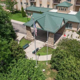 Aerial view of a hotel entrance with flags and surrounding greenery.