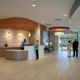 Modern reception area with people interacting in a well-lit lobby.
