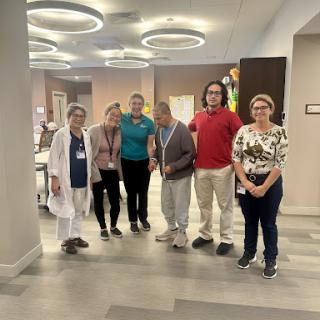 A group of healthcare professionals gathered together in a modern facility, showcasing teamwork and positivity.