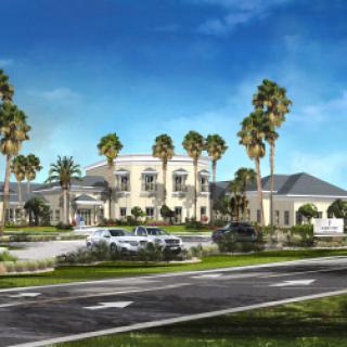 A beautifully designed residential building surrounded by lush landscaping and palm trees.