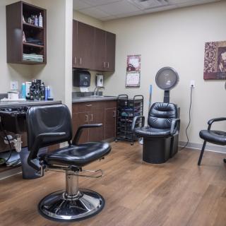 A hair salon interior featuring several chairs and hairdressing equipment.