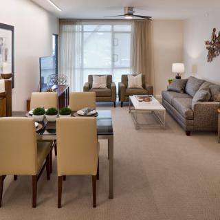A modern living room with a dining area, featuring neutral tones and stylish decor.