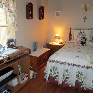 A cozy bedroom with floral decor and wooden furniture.