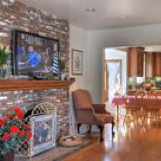 Cozy living room with a brick fireplace and a view into the kitchen.