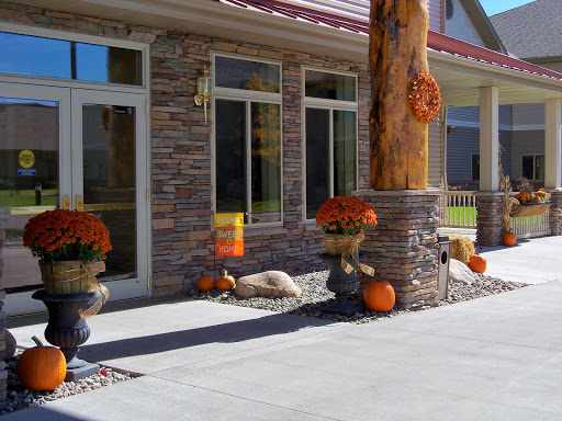 A beautifully decorated home entrance showcasing autumn decor with pumpkins and flowers.