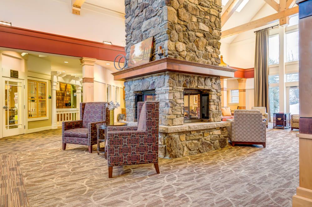 A cozy lounge area featuring a central stone fireplace and comfortable seating.