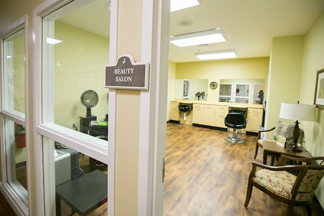 An empty beauty salon featuring styling stations, chairs, and mirrors.