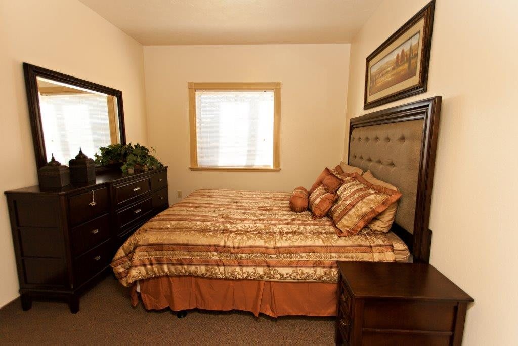 A cozy bedroom with a large bed and warm-toned decor.