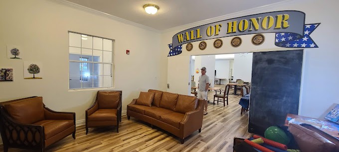 A cozy room with comfortable seating and a 'Wall of Honor' display.